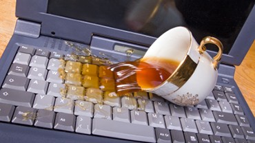 Coffee spilling on an older laptop keyboard