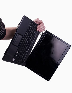 Shows an arm holding an open laptop dangling sideways with a broken or separated left hinge at the top