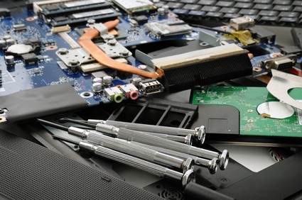 Stack of laptop parts with some small screwdrivers