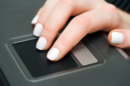 Close-up of female hand working on a laptop touchpad